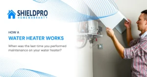 Technician performing annual water heater maintenance by draining sediment from tank for better performance